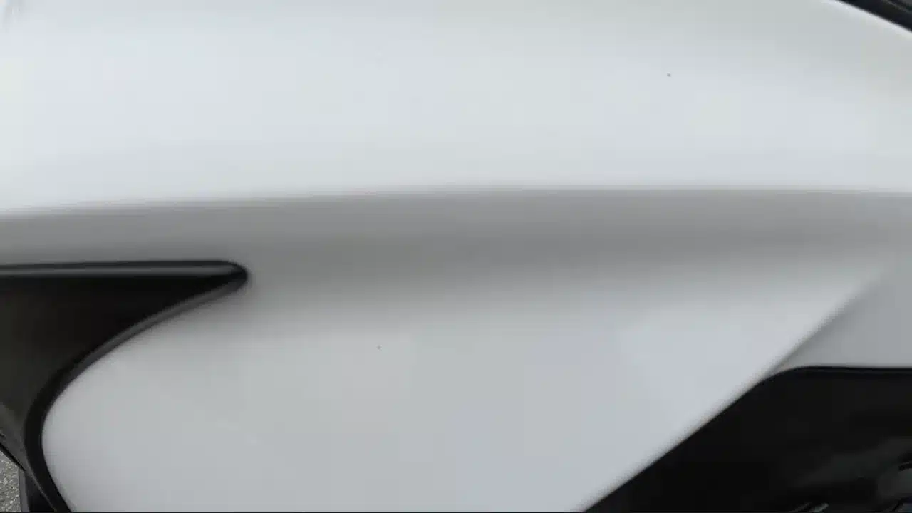 Close view of small marks on the white Camry front bumper