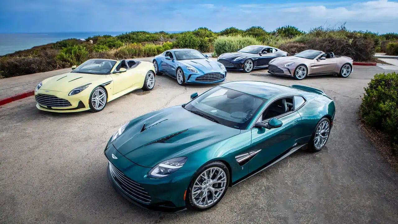 Five 2027 Aston Martin Heritage Edition sports cars parked by the coast