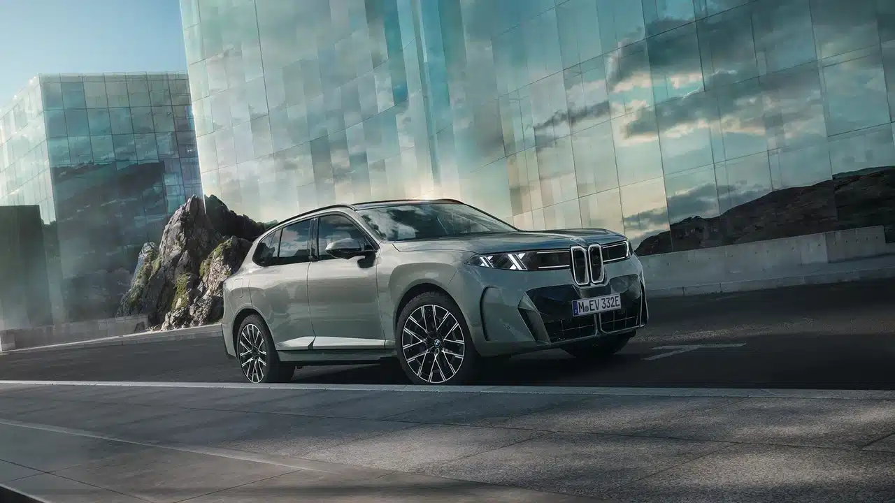 New BMW X5 family SUV beside a modern building