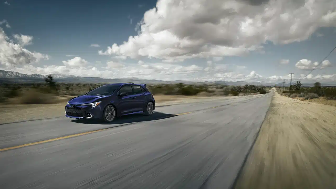 Blue 2027 Toyota Corolla Hatchback driving on an open road