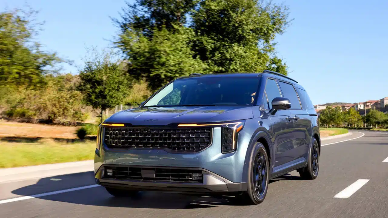 2027 Kia Carnival driving on a suburban road