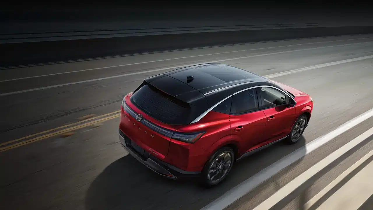 Red Nissan Murano driving on a road