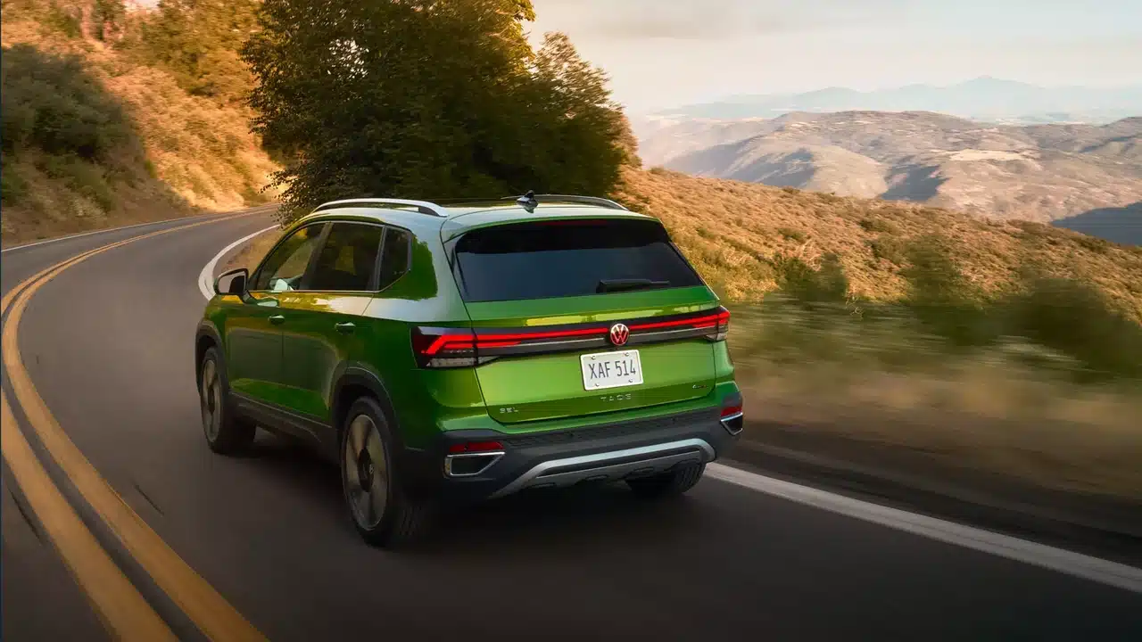Green 2027 Volkswagen Taos rear view on a mountain road
