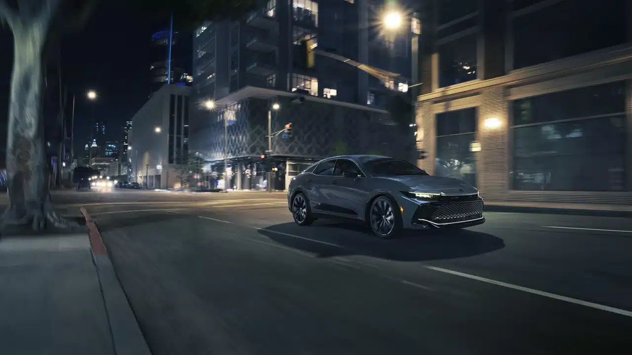2027 Toyota Crown driving through a city at night