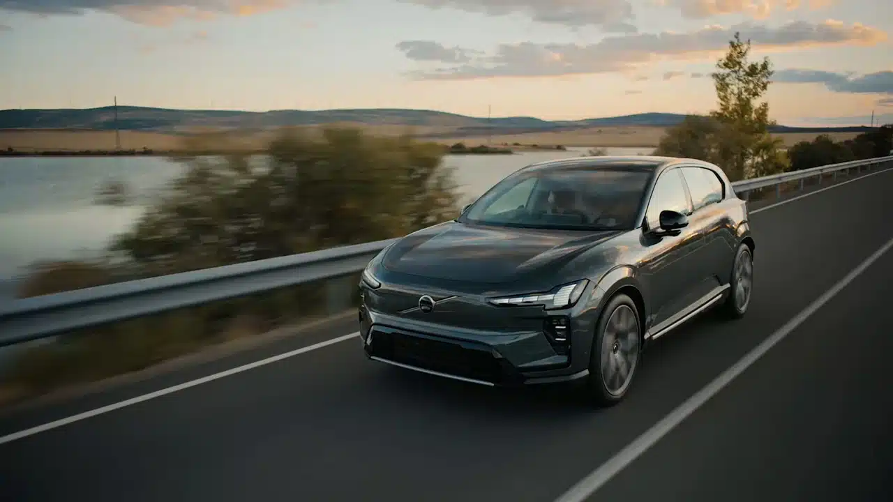 2027 Volvo EX60 driving beside a lake