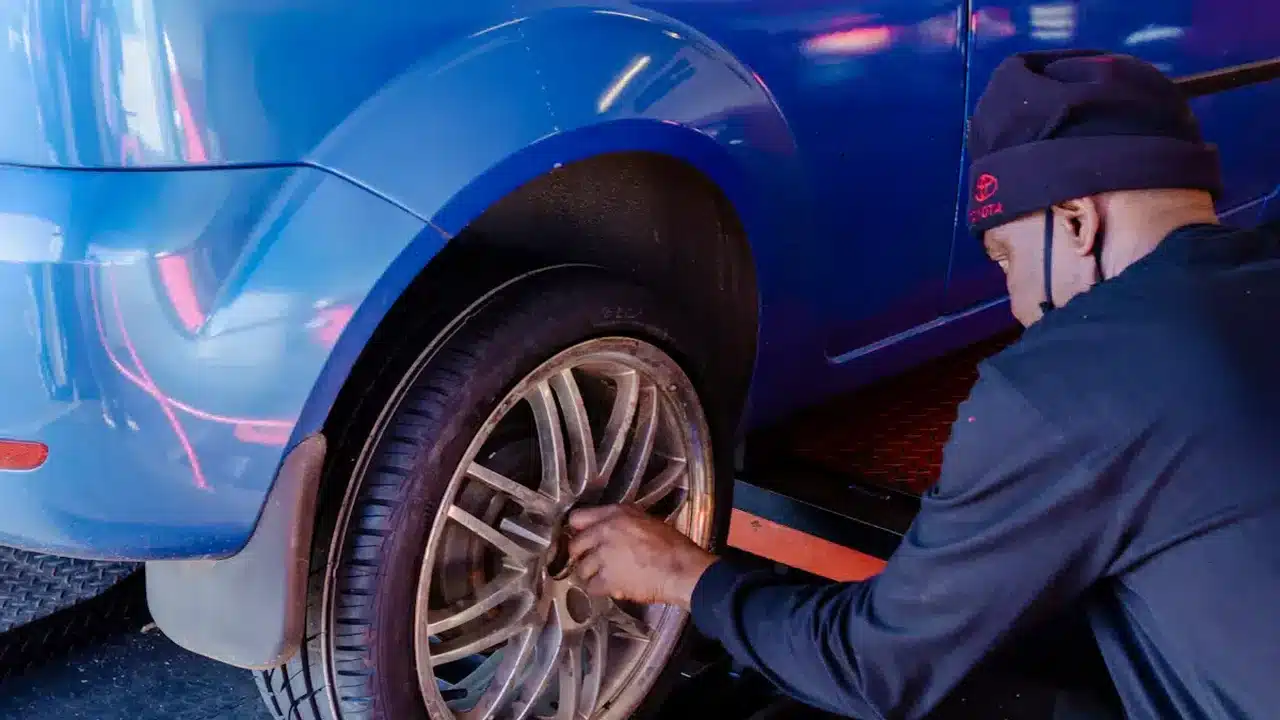 Technician working on a blue vehicle wheel