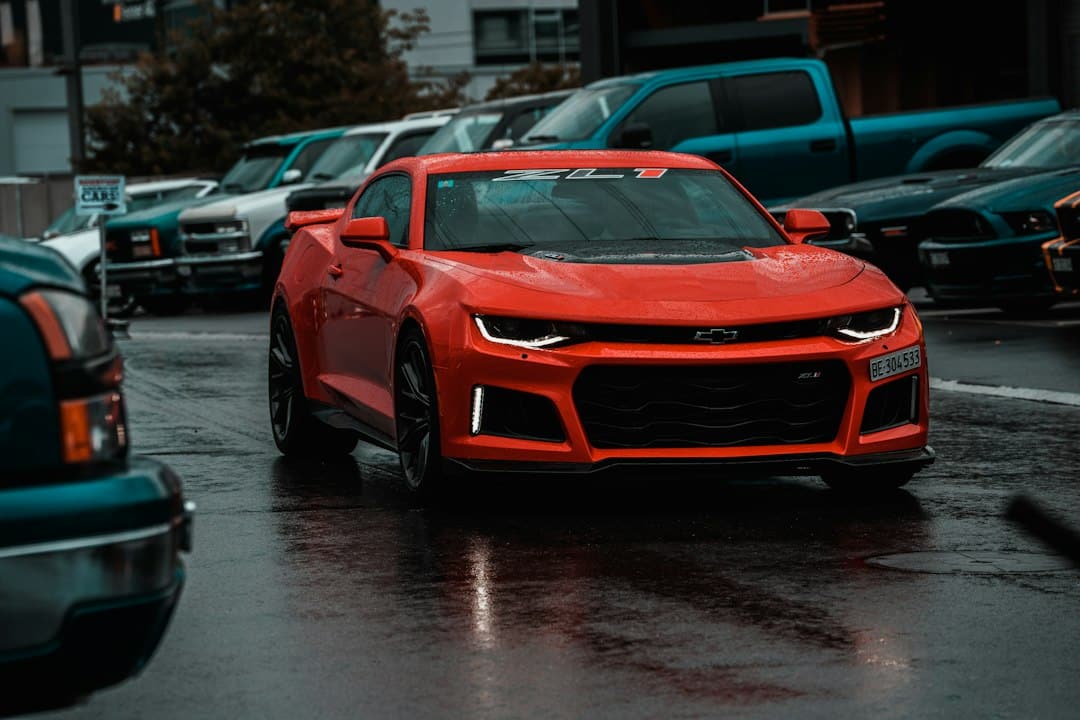 Red sixth-generation Chevrolet Camaro ZL1 photographed among parked cars