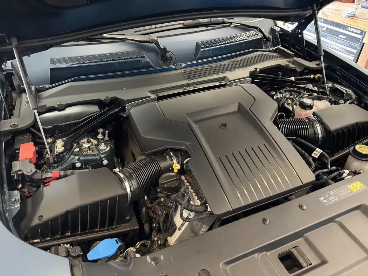 Defender OCTA engine bay with the hood raised, showing the engine cover and intake ducts.